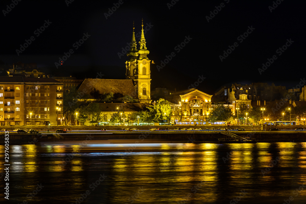 Naklejka premium View of the evening Budapest from a pleasure boat. Pest in the evening light. Night city. Danube river at night. Walk and tour the Danube.
