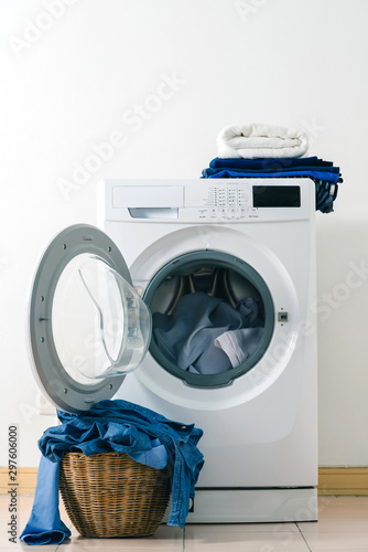 Close up washing machine and clothes in basket on white background. Laundry concept.