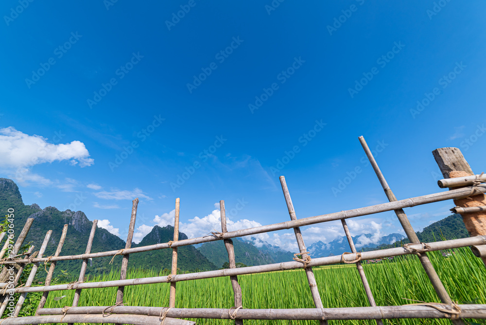 Fototapeta premium Beautiful Rice Field and Mountains with Clouds Blue Sky in Vang Vieng, Laos