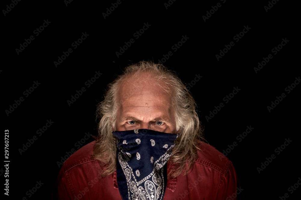 portrait of llong haired masked bandit wearing a blue bandana to cover the  face and a red shirt looking intently at viewer with dark background. Stock  Photo | Adobe Stock