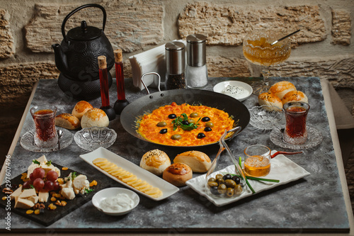 traditional azerbaijani breakfast with egg and tomato dish, tea, honey, butter