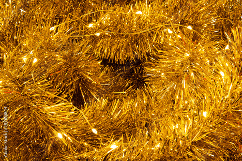 Close up of gold garland with sparkling lights on it. Christmas decoration, theme background. New Years party.