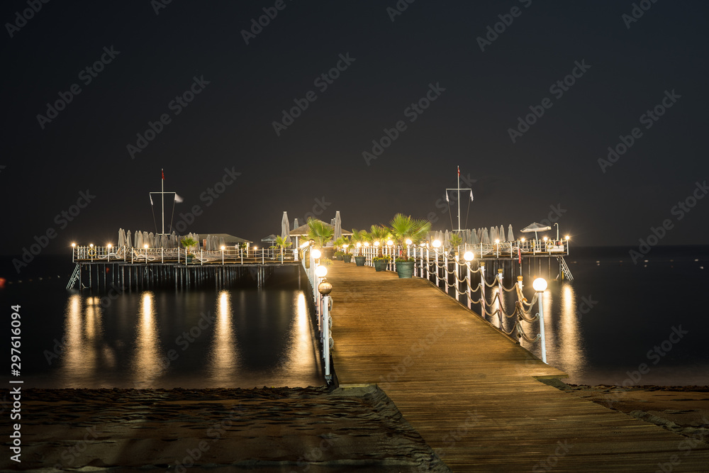standing on the beach looking to the dock at night in turkey