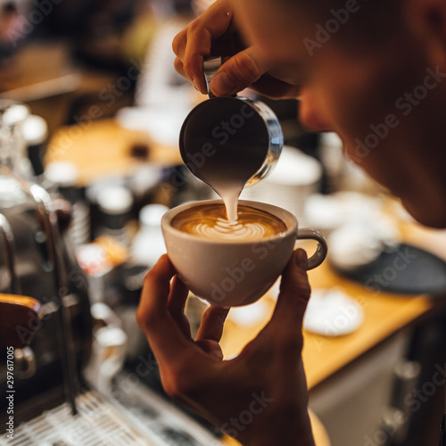 Barista making cappuccino in white cup.