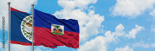 Fotografie Belize and Haiti flag waving in the wind against white cloudy blue sky together