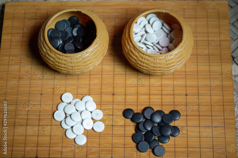 Go board game playing. A competitor is placing a marble piece on a Go board game. Go board game playing. A competitor is placing a marble piece on a Go board game.