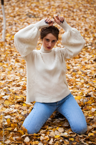 Young beautiful girl in blue jeans and gwhite sweater photo