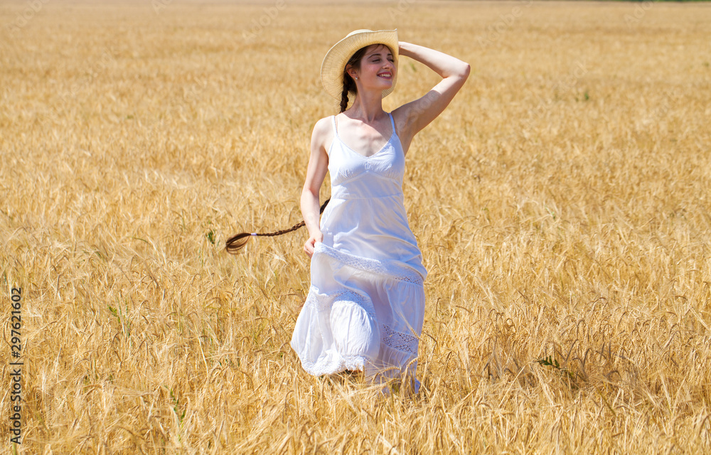 Young brunette woman in white dress walking in a wheat field Young brunette woman in white dress walking in a wheat field