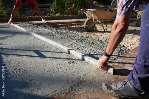  Construction workers working outdoors pouring concrete.