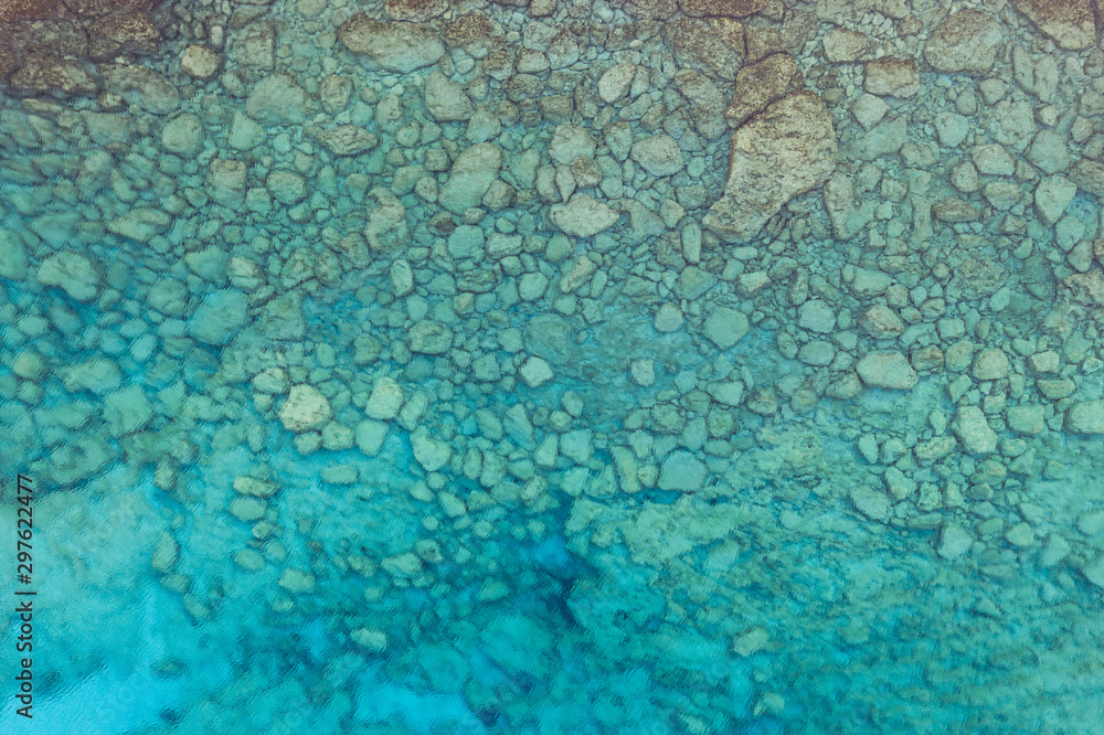 An aerial view of the beautiful Mediterranean sea, where you can se the rocky textured underwater corals and the clean turquoise water of blue lagoon Agia Napa An aerial view of the beautiful Mediterranean sea, where you can se the rocky textured underwater corals and the clean turquoise water of blue lagoon Agia Napa