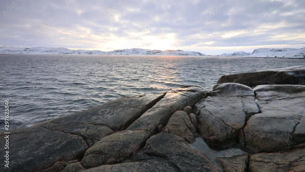 Rocky shore of the Barents Sea in winter at sunset Rocky shore of the Barents Sea in winter at sunset