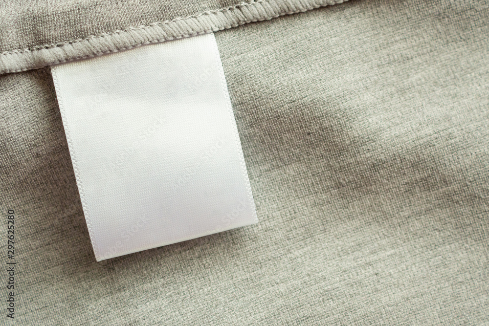 White blank laundry care clothing label on gray fabric texture background - obrazy, fototapety, plakaty 
