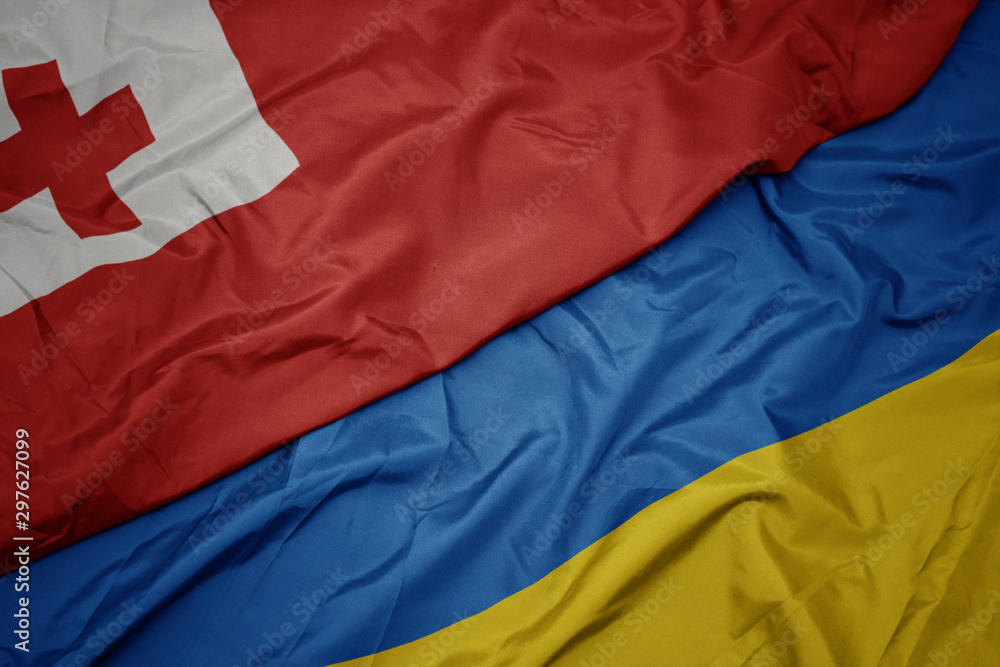 waving colorful flag of ukraine and national flag of Tonga .