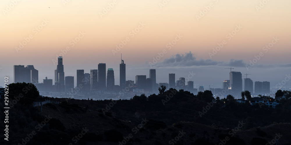 Twilight panorama view of downtown Los Angeles towers and hilltop ridge near popular Griffith Park in scenic Southern California.