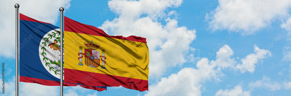 Belize and Spain flag waving in the wind against white cloudy blue sky together. Diplomacy concept, international relations. Belize and Spain flag waving in the wind against white cloudy blue sky together. Diplomacy concept, international relations.