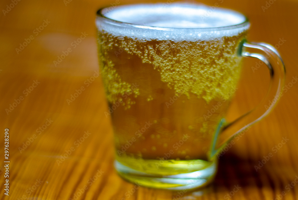 yellow juice in a glass, on a beige background yellow juice in a glass, on a beige background