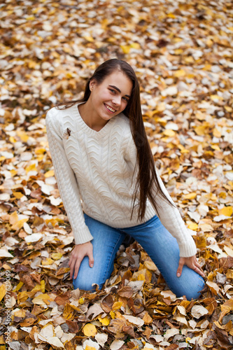 Young beautiful girl in blue jeans and gwhite sweater