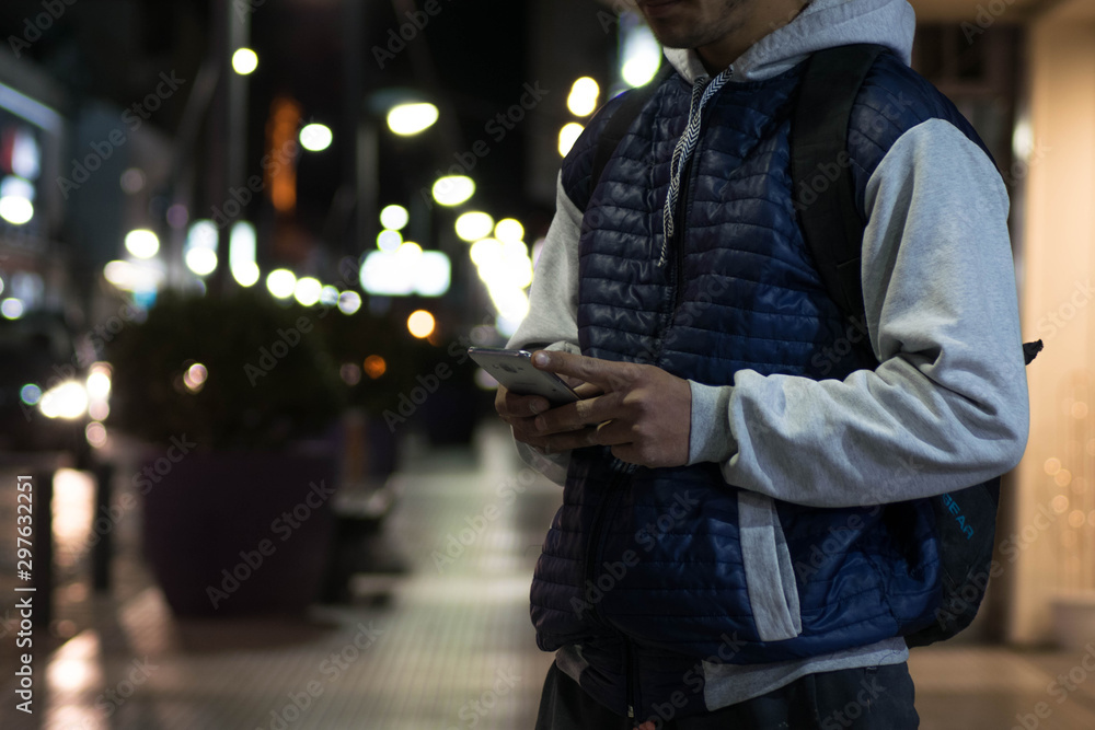 Hombre en la calle enviando mensajes desde el celular