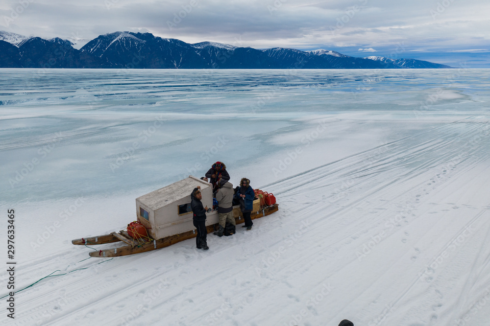 Tourists travelling by Qamutiik on the sea ice near Sirmilik National Park in Nunavut, Canada