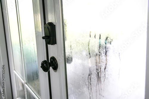 The humidity of the outdoor temperature on a summer day in South Georgia. The air conditioning is on inside and the cold air inside makes the back glass pane doors condensate and become foggy.