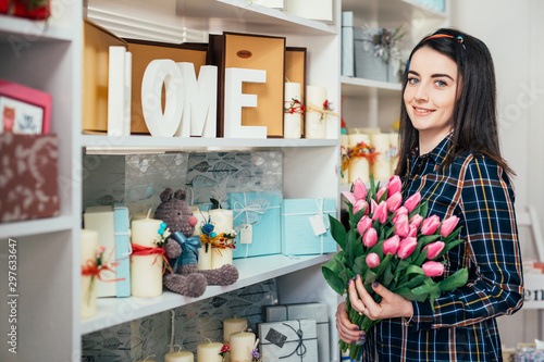 Portrait of a girl holding a bouquet next to a wardrobe.