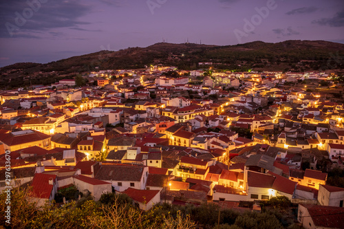 overview of the village of montanchez in the evening with the illuminated streets and the colored sky, extremadura, caceres, spain