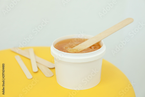 Liquid yellow paste for shugaring on yellow background, space for text