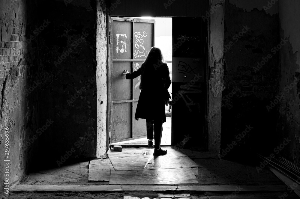 Female silhouette leaving from room. Evokes a feeling of loneliness.