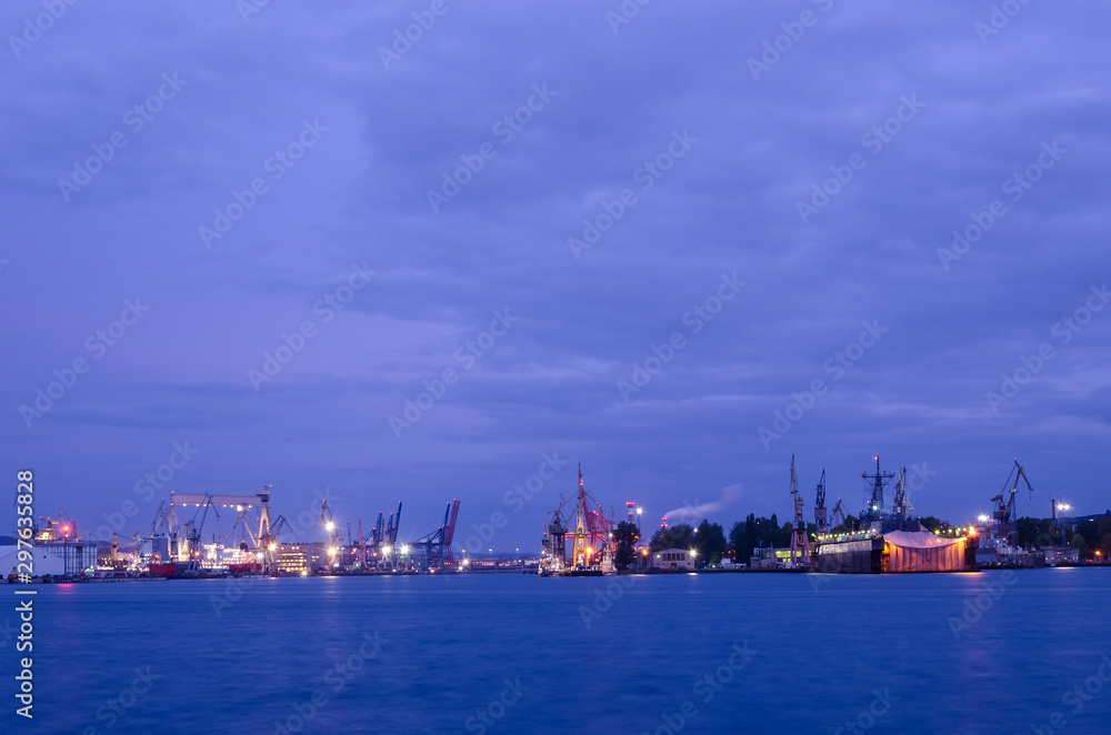 EVENING HARBOR LIFE - Illuminated waterfront and repair dock of the Navy shipyard i Gdynia