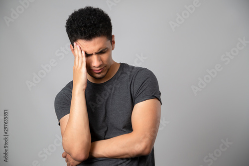 Young man with headache- young Hispanic man with hand on head