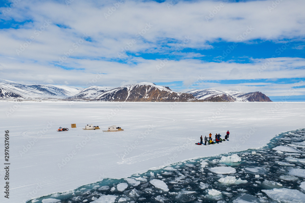 Aerial drone photo of tourists visit the floe edge near Sirmilik National Park in Nunavut, Canadaa