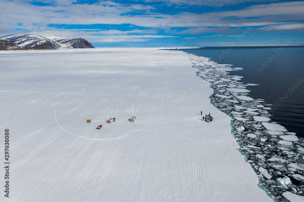 Aerial drone photo of tourists visit the floe edge near Sirmilik National Park in Nunavut, Canadaa