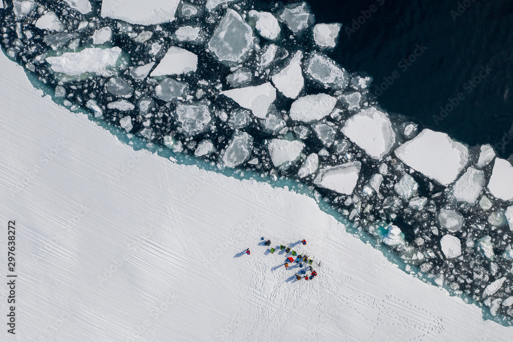 Aerial drone photo of tourists visit the floe edge near Sirmilik National Park in Nunavut, Canadaa