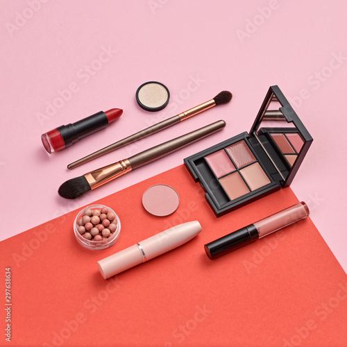 Fashion beauty coral product layout. Woman Essentials cosmetic makeup Set. Collection beauty accessories. Trendy Eye shadow, Brushes, lipstick. Coloful red art Flat lay.Creative make up artist concept
