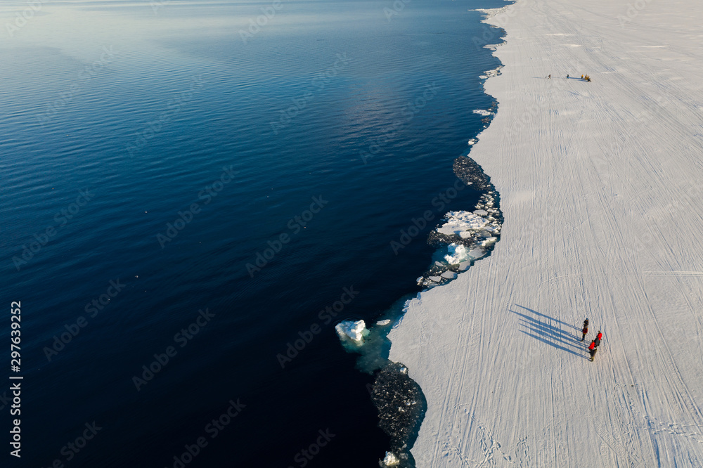 Aerial drone photo of tourists visit the floe edge near Sirmilik National Park in Nunavut, Canadaa