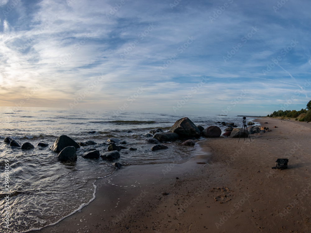 Fototapeta premium defocused clouds over Baltic sea after sunset during blue hour, natural rocks, long time exposure with blurred reflections in water