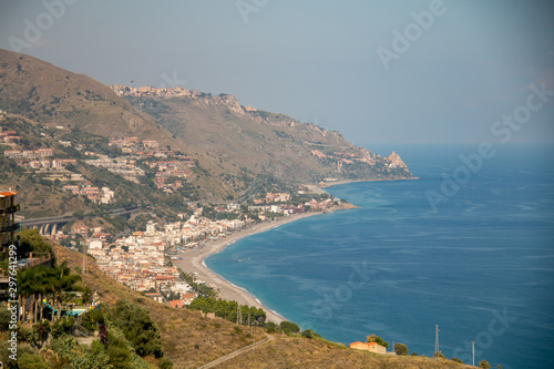  Eaux bleues aquatiques de la mer et fantastique paysage urbain de Taormina au coucher du soleil. Baie de Giardini-Naxos, côte de la mer Ionienne, Taormine, Sicile, Italie.