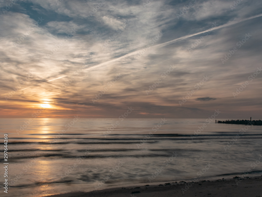 landscape with defocused beautiful dramatic golden sky over the sea, reflection at sunset time, long exposure 