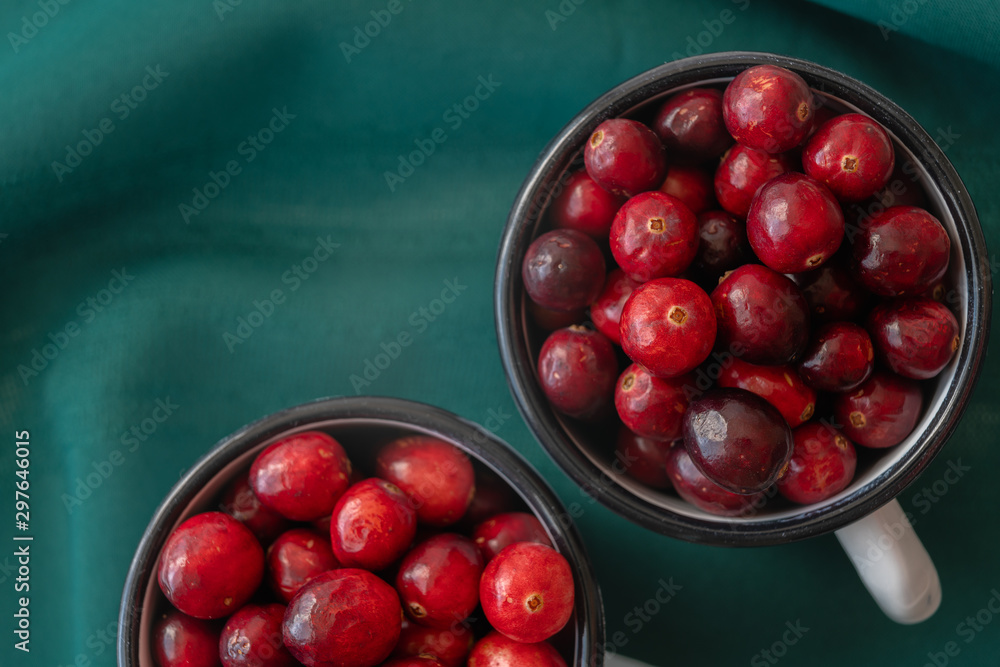 Cranberries. Fresh ripe organic cranberries in a cups directly from above with green background, close up Cranberries. Fresh ripe organic cranberries in a cups directly from above with green background, close up