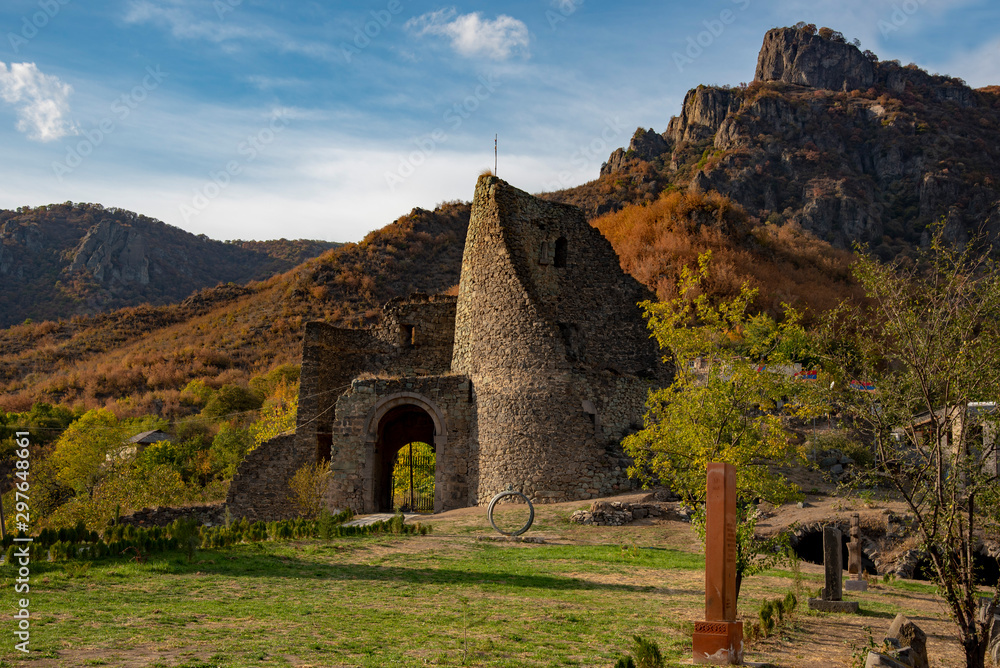 Ruined brick old tower, wall and gate against the background of mountains and sky. Ruined brick old tower, wall and gate against the background of mountains and sky.