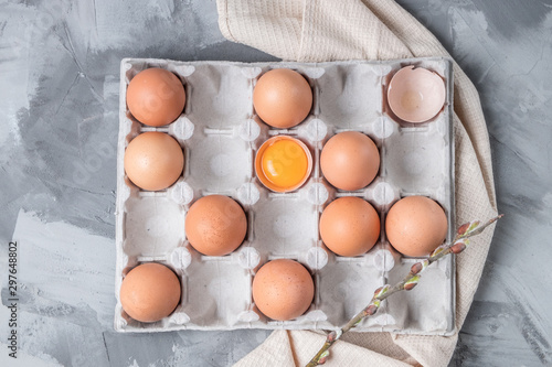 cardboard box with brown eggs and blooming willow around