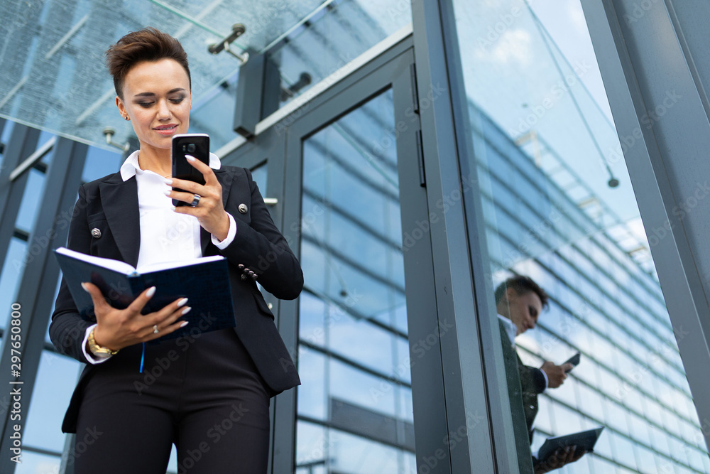 beautiful busineswoman making notes against modern building