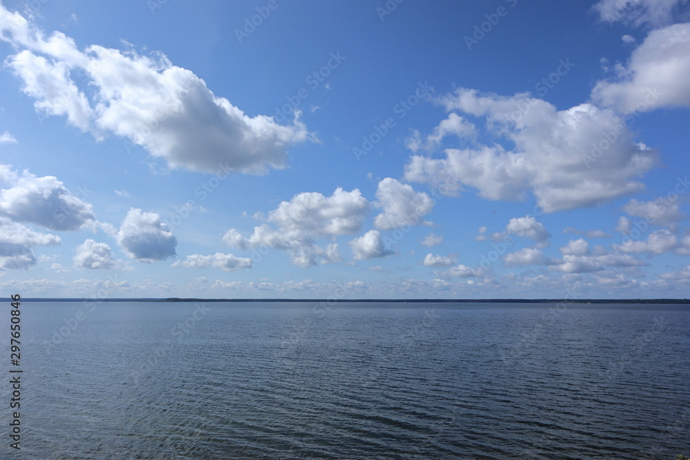 Beautiful Belarus skyscape on big lake in national park with sparkling water and marvelous clouds in blue sky landscape background