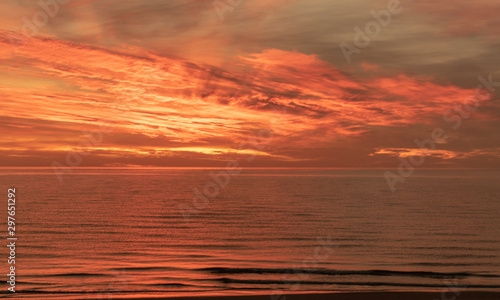 landscape with defocused beautiful dramatic golden sky over the sea, reflection at sunset time, long exposure 