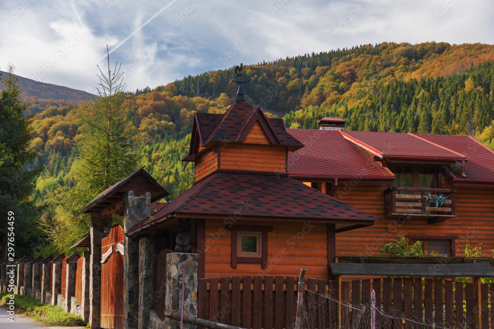 Fototapeta premium Landscapes on an autumn mountain village, with beautiful houses and golden trees around, located in the Ukrainian Carpathians.