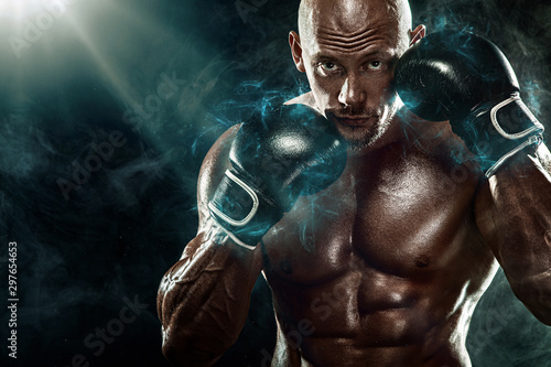 Sportsman, man boxer fighting in gloves on black background. Fitness and boxing concept. Individual sports recreation.