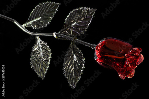 Red and silver colored metallic rose with droplets on black background.