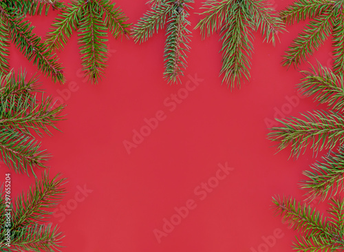 Frame Created Using Green Pine Branches Against Red Background