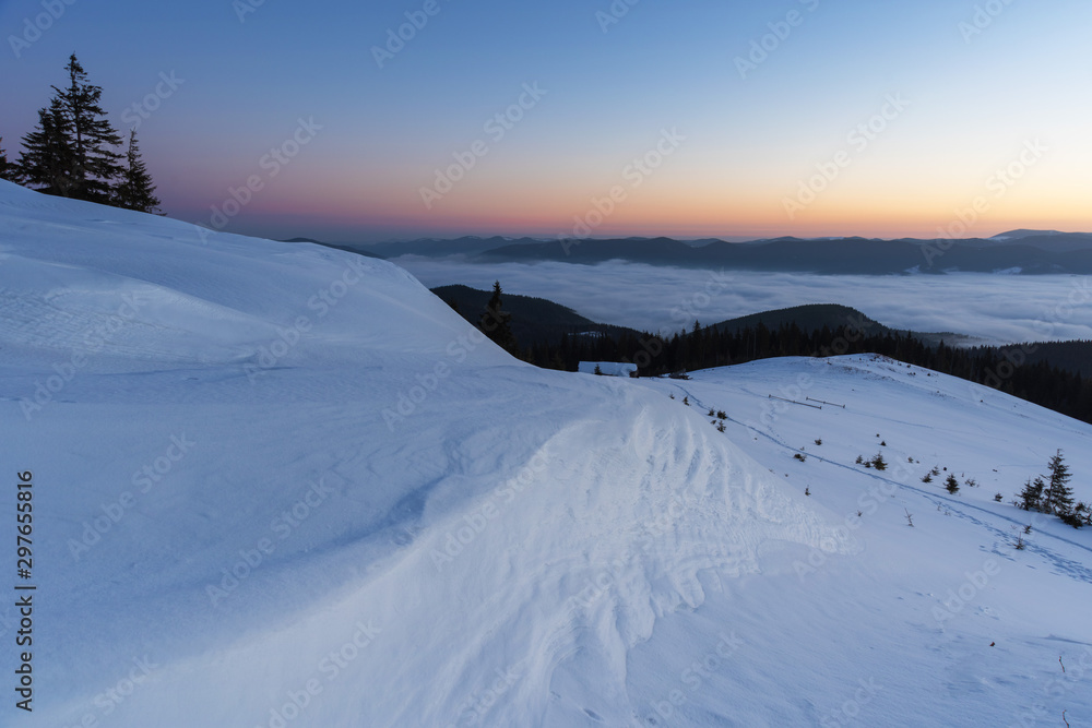Beautiful winter landscapes from the Ukrainian Carpathian Mountains with traumatic skies and tourists, traveling on ridges