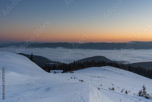 Beautiful winter landscapes from the Ukrainian Carpathian Mountains with traumatic skies and tourists, traveling on ridges